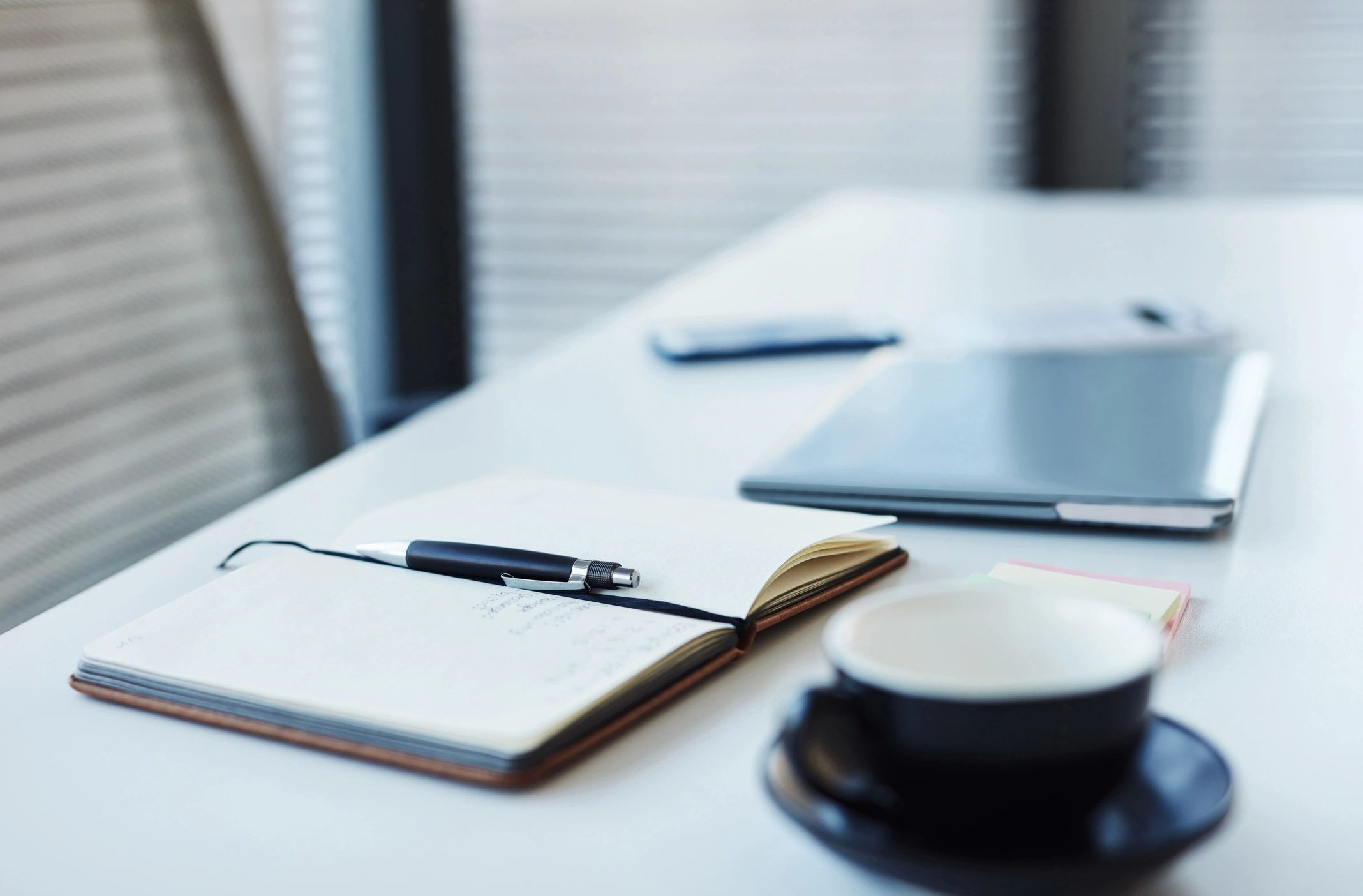 Laptop and notebook on a desk—writing and planning content