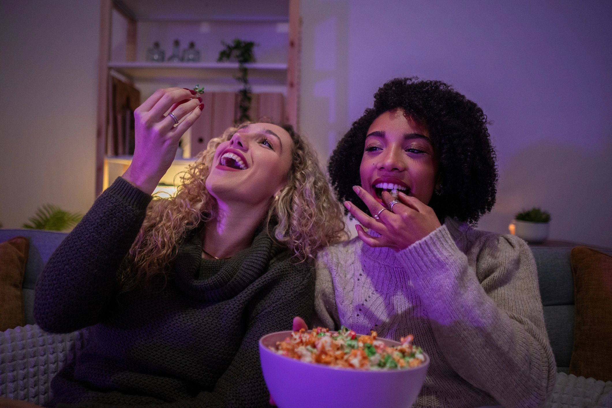 Friends watching a movie at home with popcorn